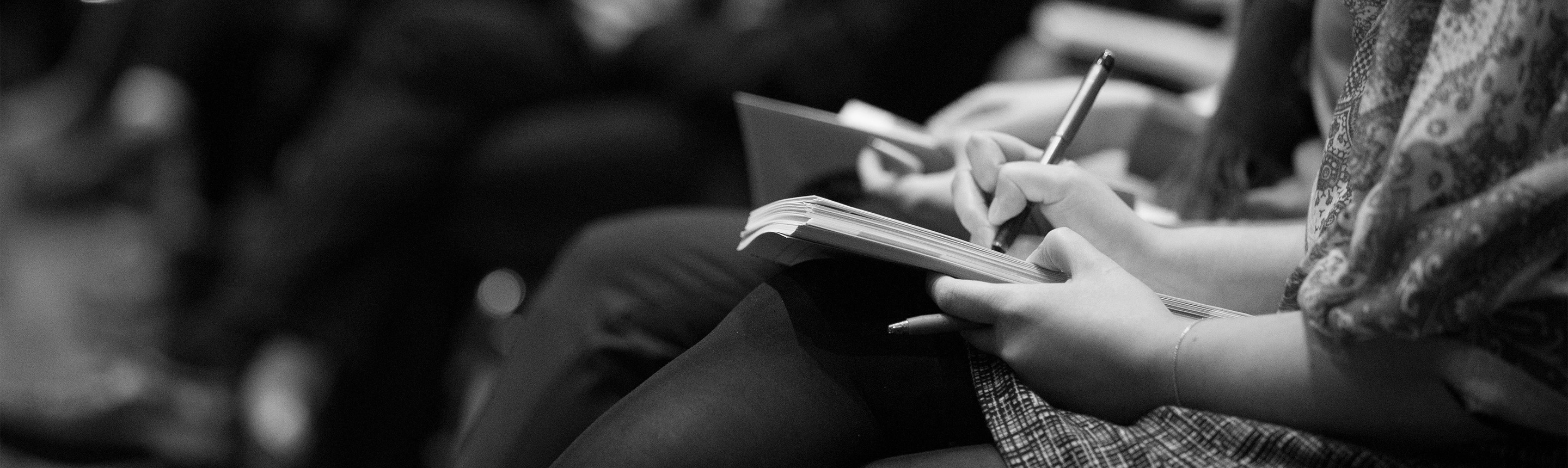 Image of media person or journalist taking notes in a notebook