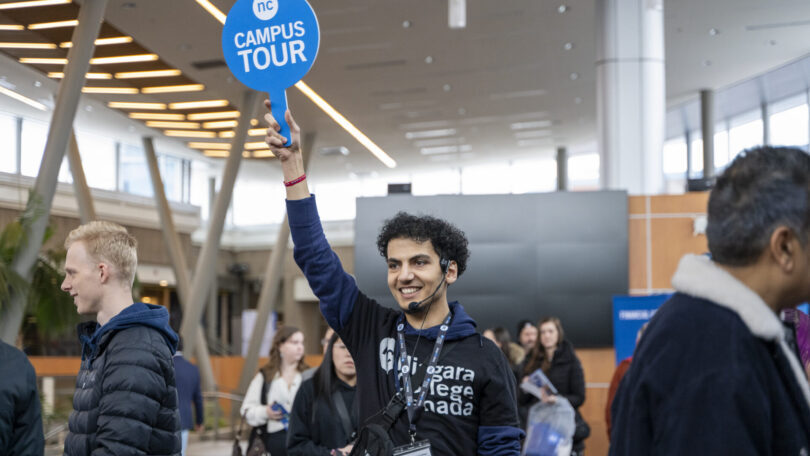 Student holds up sign at niagara college open house