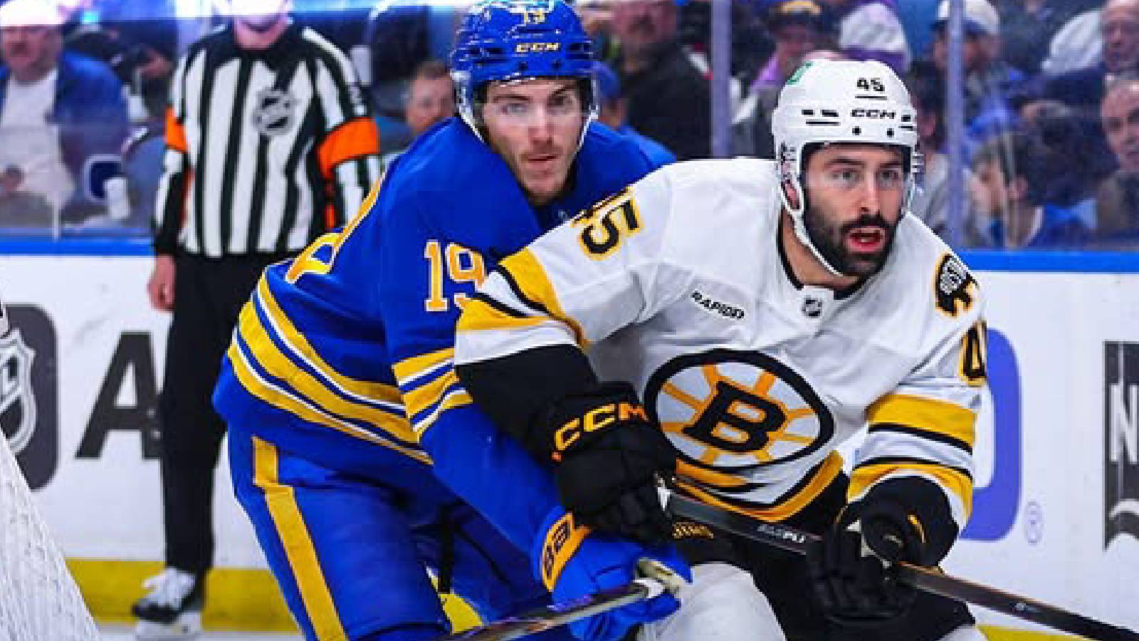 Two hockey players are seen fighting for the puck