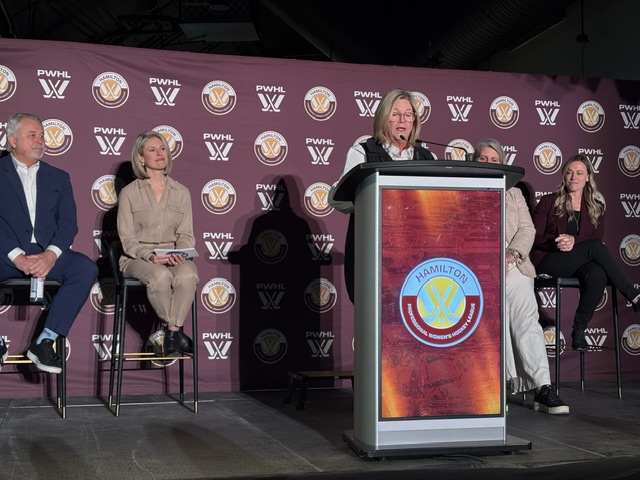 Hamilton Mayor Andrea Horwath on stage at the TD Coliseum for the announcement of the PWHL expansion into Hamilton, Ontario. She shares the stage with Ontario Minister of Sport Neil Lumsden, Jocks in Jills Podcast co-host Tessa Bonhomme, CBO for Oak View Group Amy Latimer, and Executive Vice President of Hockey Operations for the PWHL Jayna Hefford.