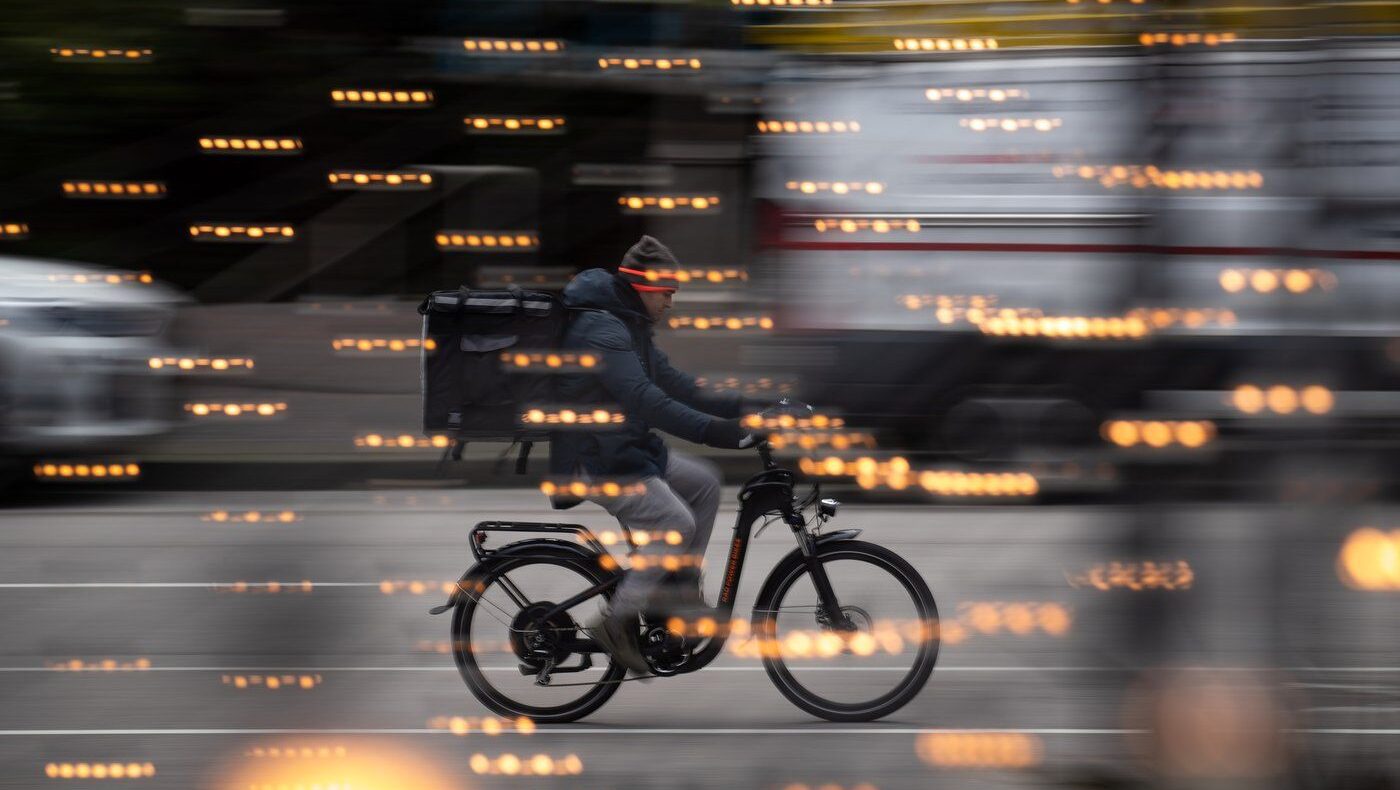 A food delivery worker rides a bike in downtown Vancouver