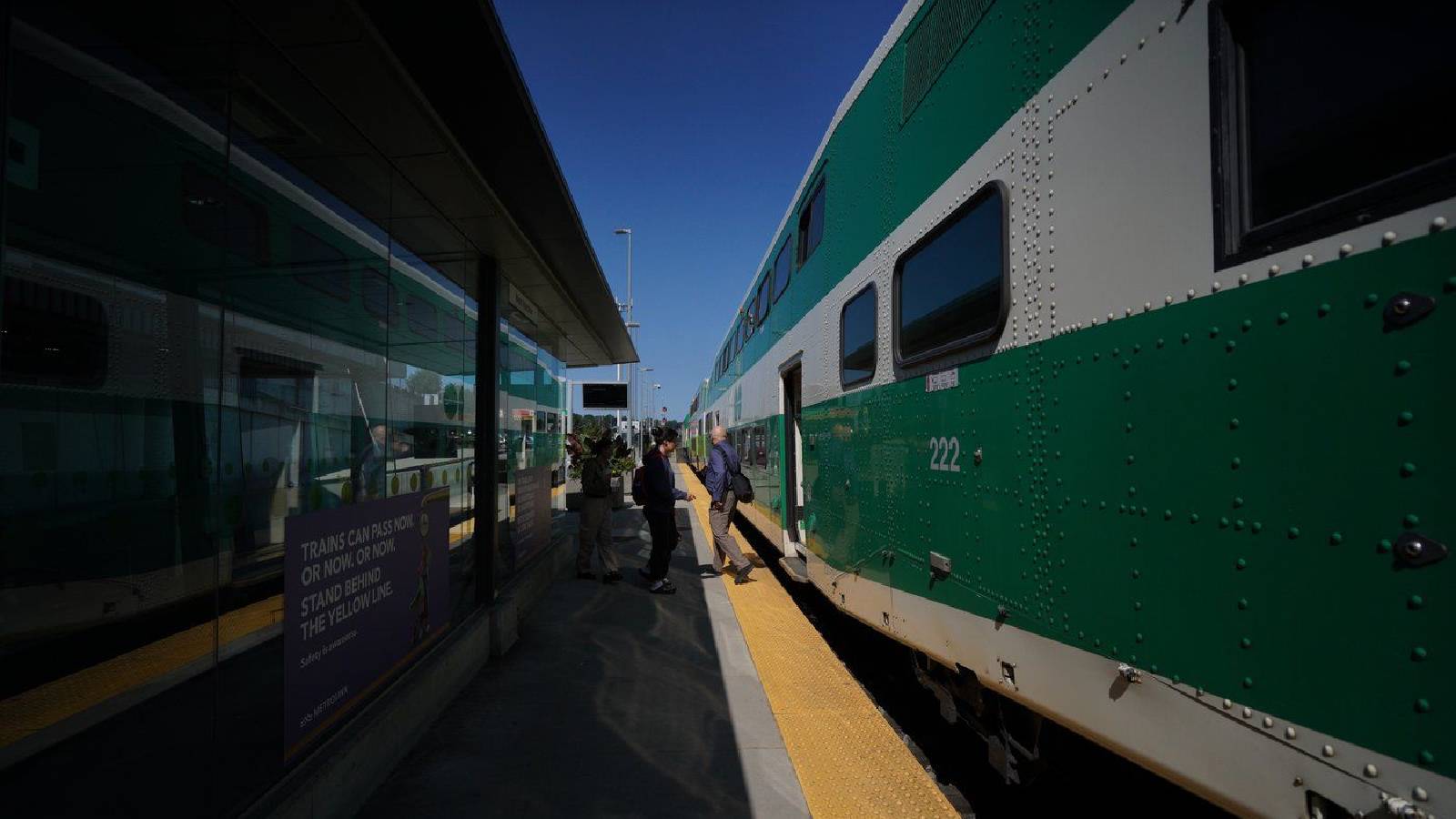 Commuters exit and board a GO train at the West Harbour GO station in Hamilton, Ont.